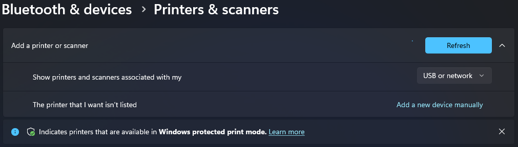 Printers and scanners page in Windows 11 with Add a new device manually next to The printer that I want isn't listed